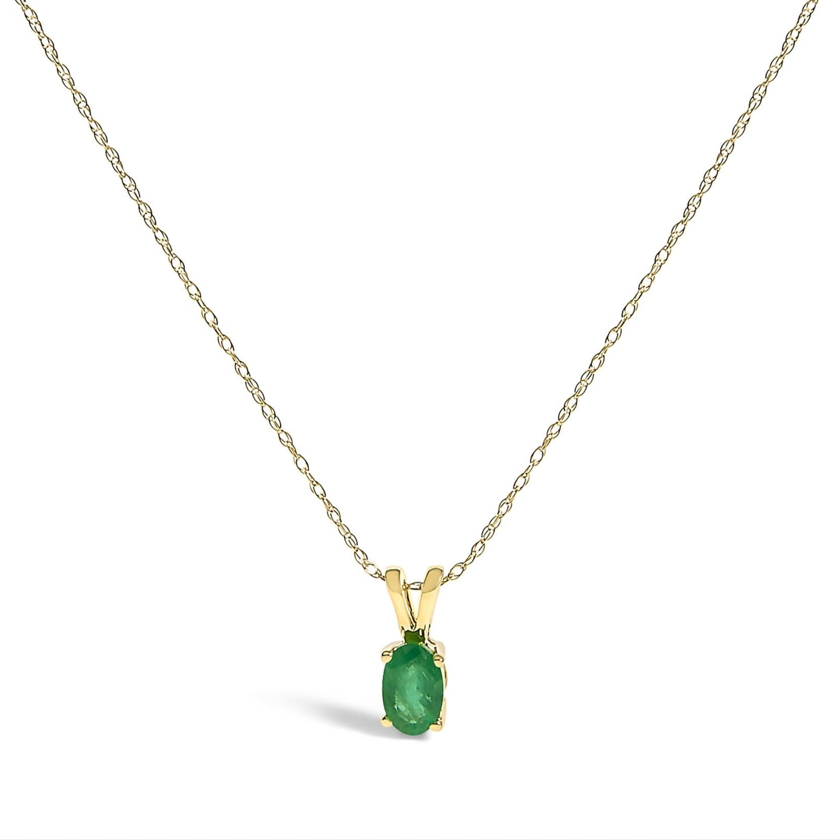 Gold necklace with a green emerald gemstone pendant on a white background