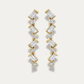Gold zigzag earrings with diamonds on a light gray background