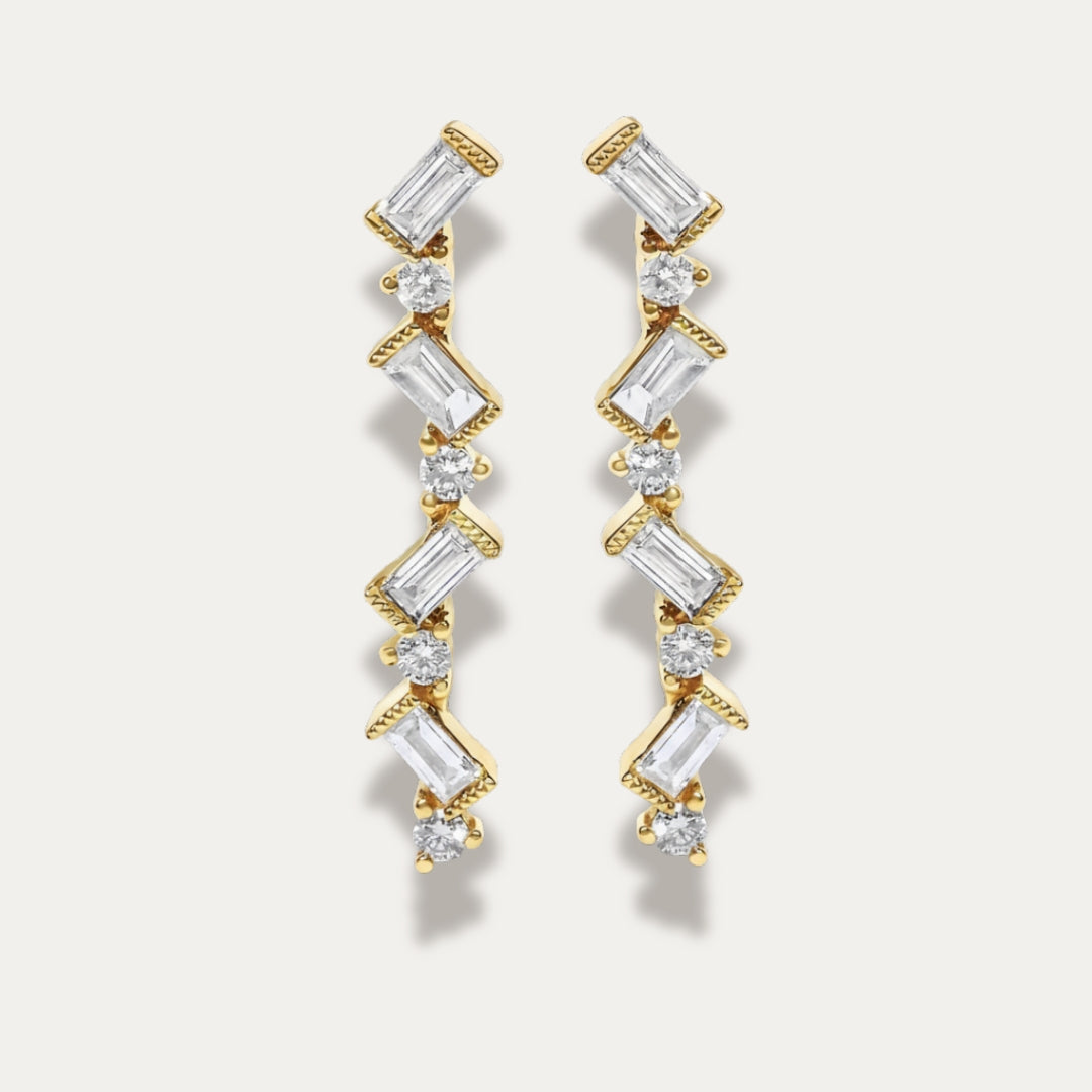 Gold zigzag earrings with diamonds on a light gray background