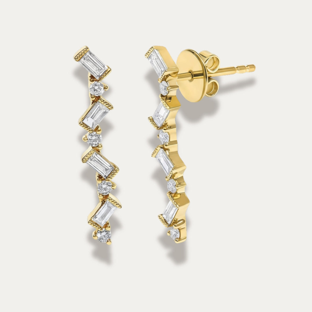 Gold zigzag earrings with diamonds on a light gray background