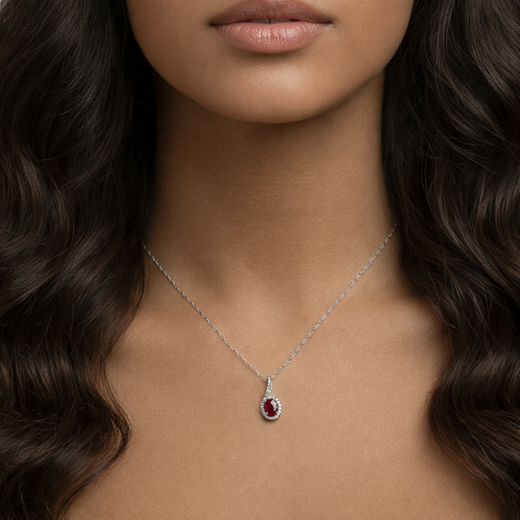 Model wearing the Carmine Teardrop Pendant Necklace by Teraju, featuring a deep red ruby teardrop gemstone set in white gold.