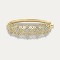 Gold bracelet with floral design and embedded diamonds on a light gray background