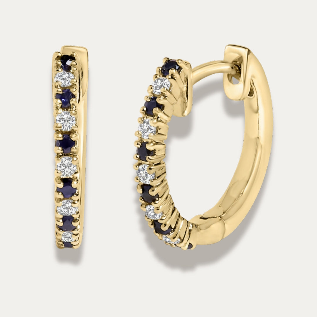 Gold hoop earrings with embedded gemstones on a white background