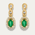 Gold earrings with green gemstones and small diamonds on a white background
