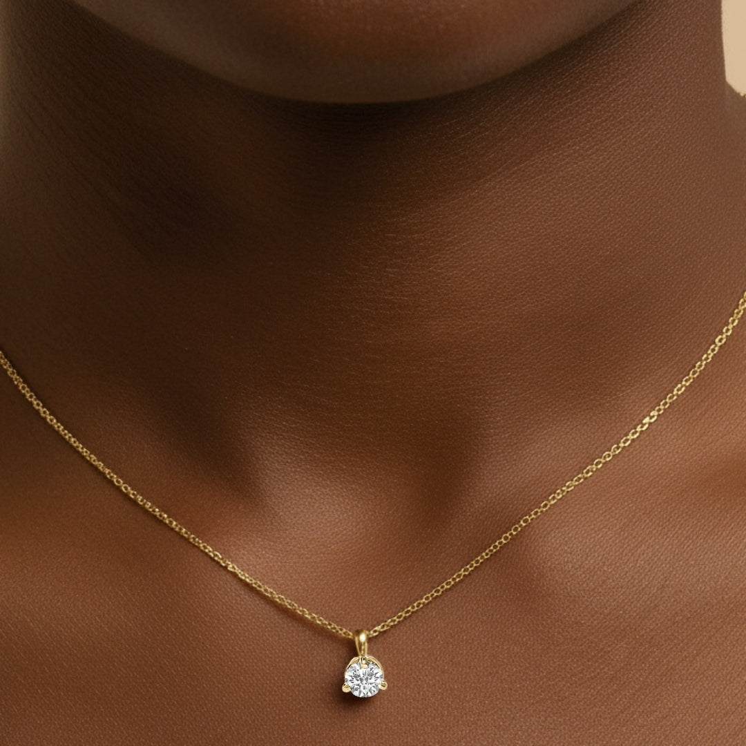 Gold necklace with a diamond pendant on a model