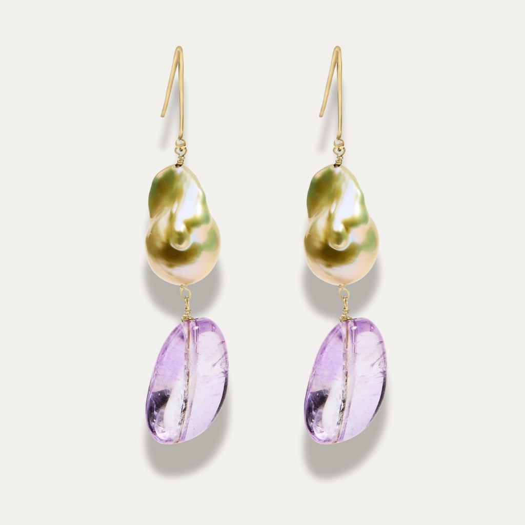 Pair of earrings with gold hooks, pearl and amethyst purple teardrop on a light grey background