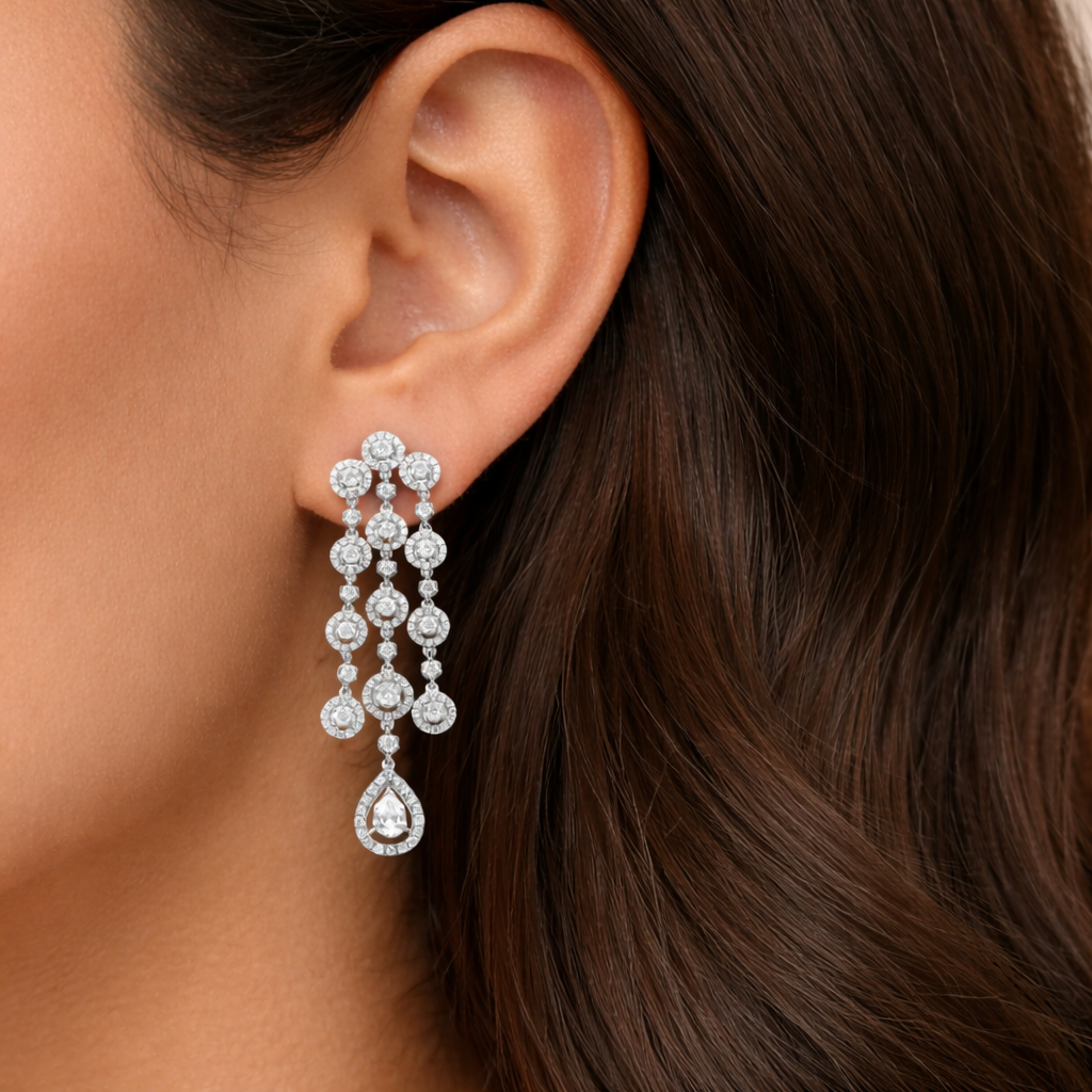 Close-up of a woman's ear wearing a diamond earring with dangling drops.