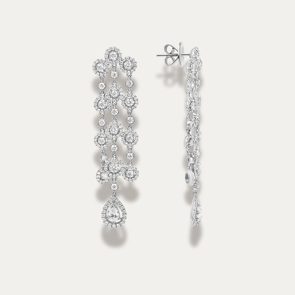 White gold earrings with diamond gemstones on a light gray background