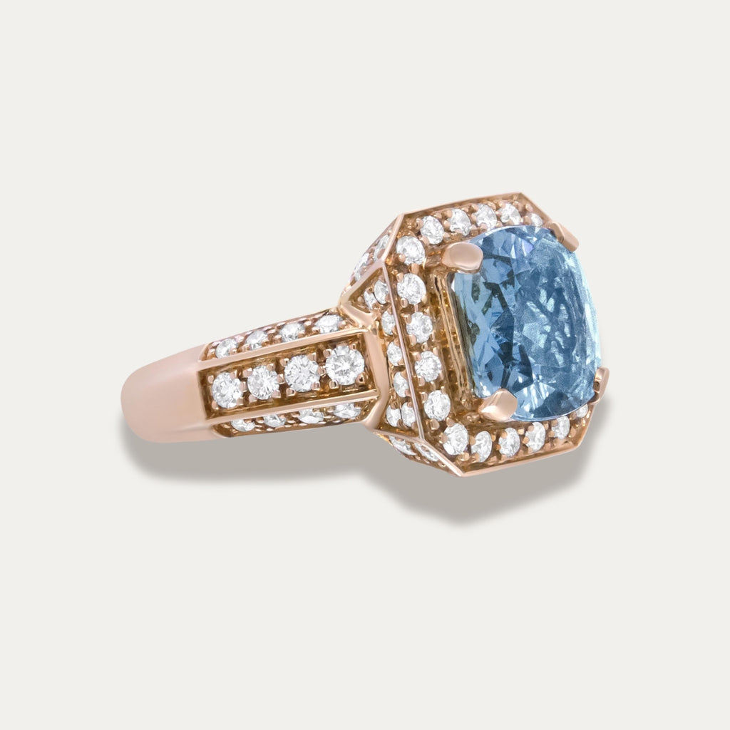 Rose Gold 18K Ring with aquamarine gemstone and rose gold setting on a light gray background