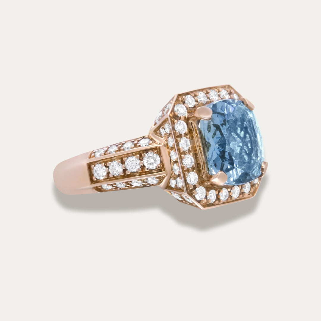 Rose Gold 18K Ring with aquamarine gemstone and rose gold setting on a light gray background