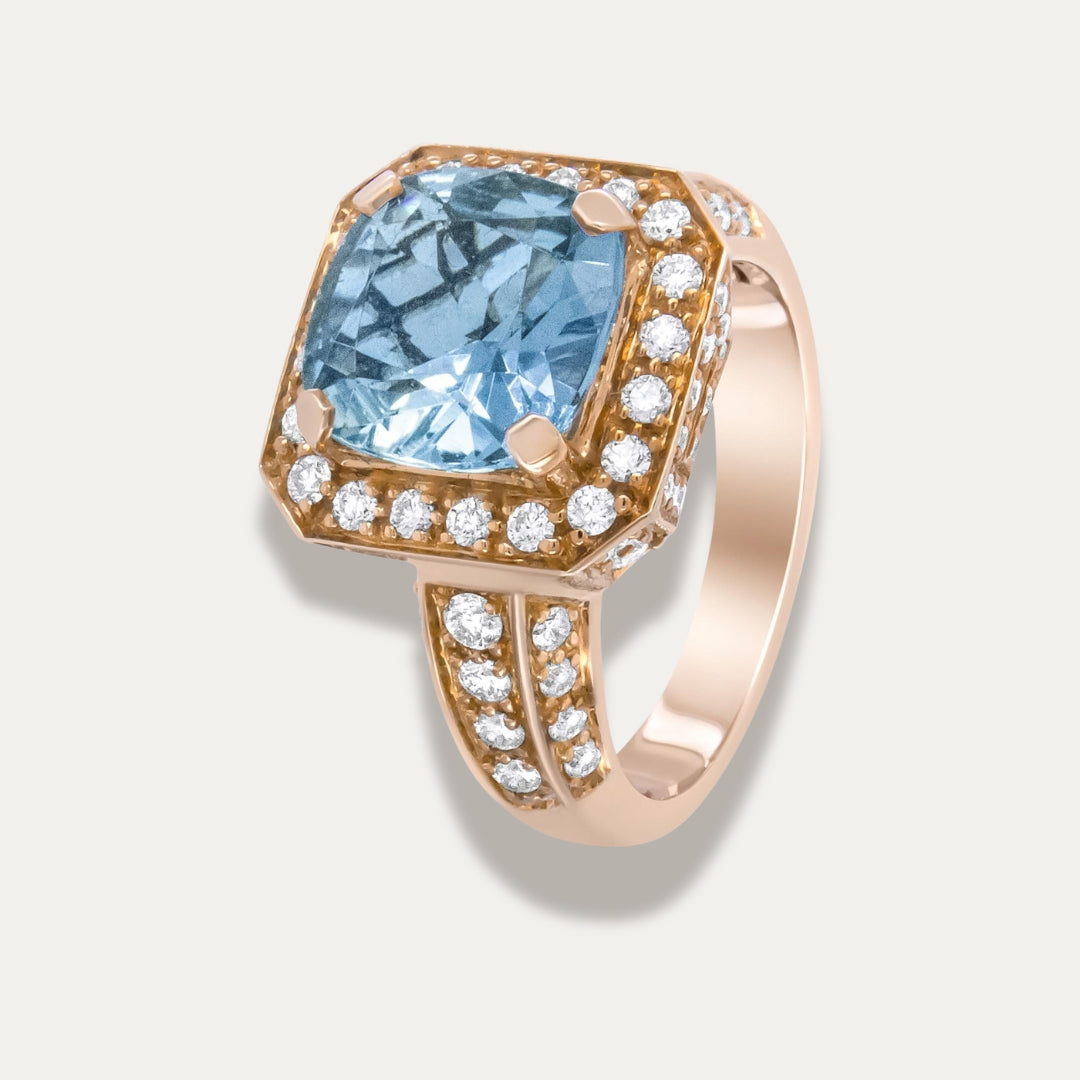 18K Rose gold ring with a blue aquamarine gemstone and diamond accents on a light gray background