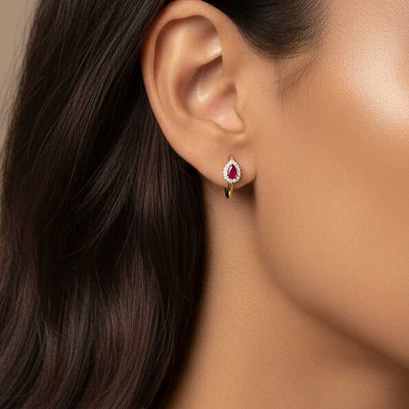 Close-up of a woman wearing a ruby earring with a neutral background