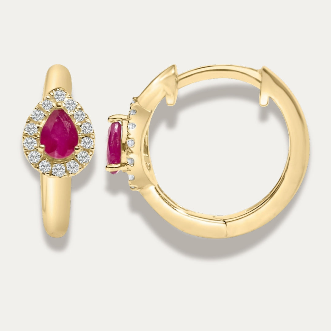 Gold hoop earrings with red ruby gemstones and dimonds on a light gray background