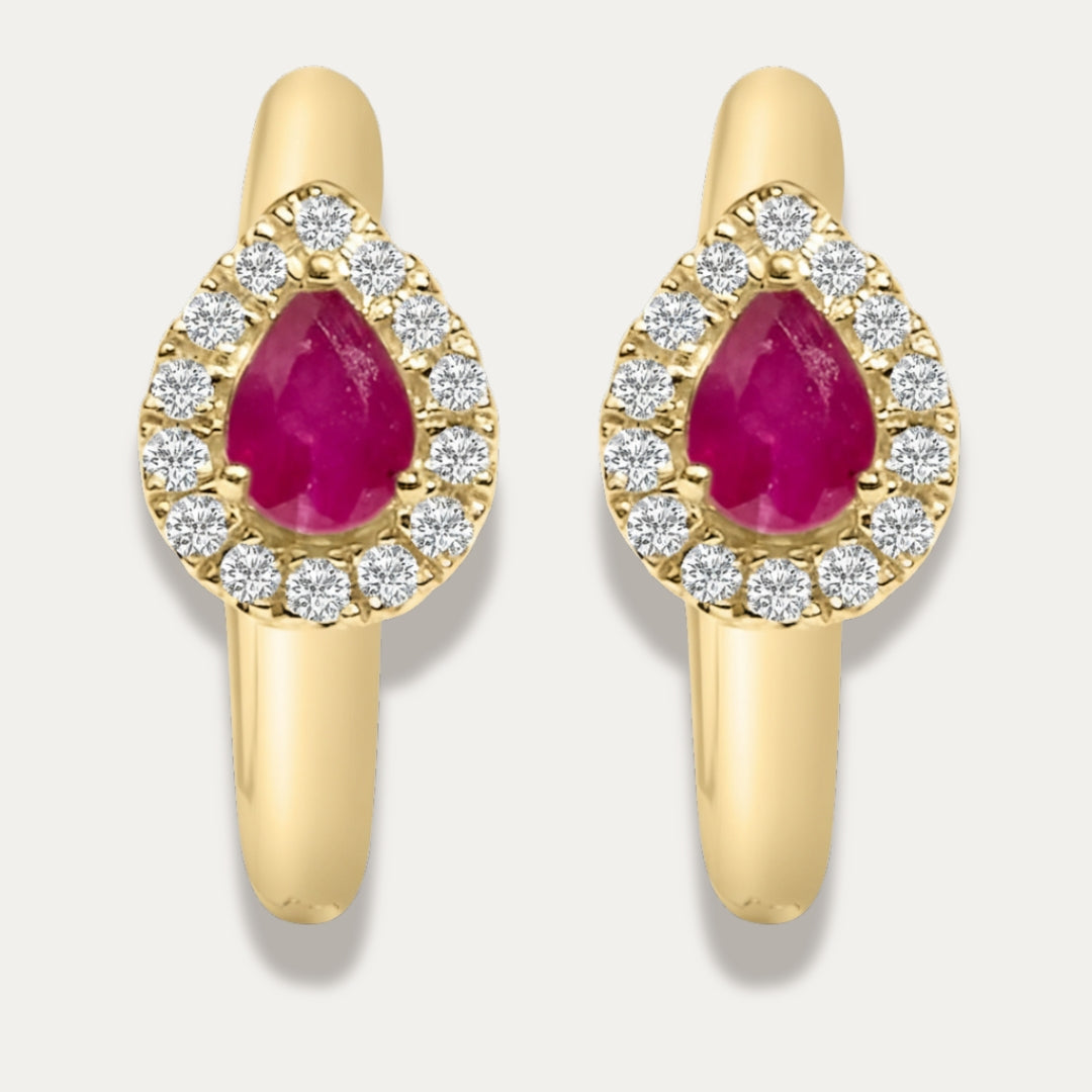 Gold hoop earrings with red ruby gemstones and dimonds on a light gray background