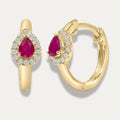 Gold hoop earrings with red ruby gemstones and dimonds on a light gray background