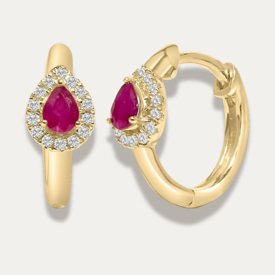 Gold hoop earrings with red ruby gemstones and dimonds on a light gray background