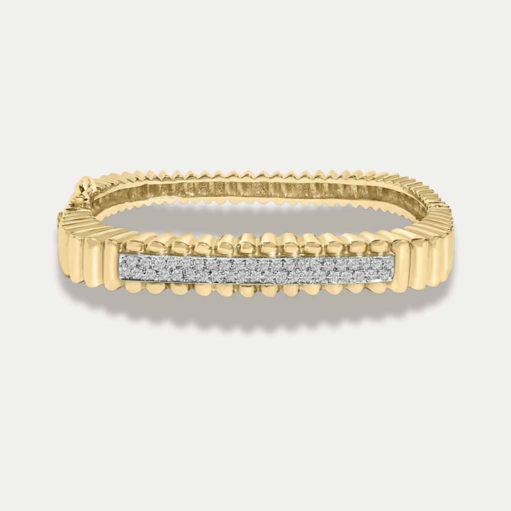 Gold bracelet with diamond bar on a light gray background