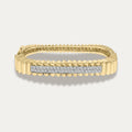 Gold bracelet with diamond bar on a light gray background