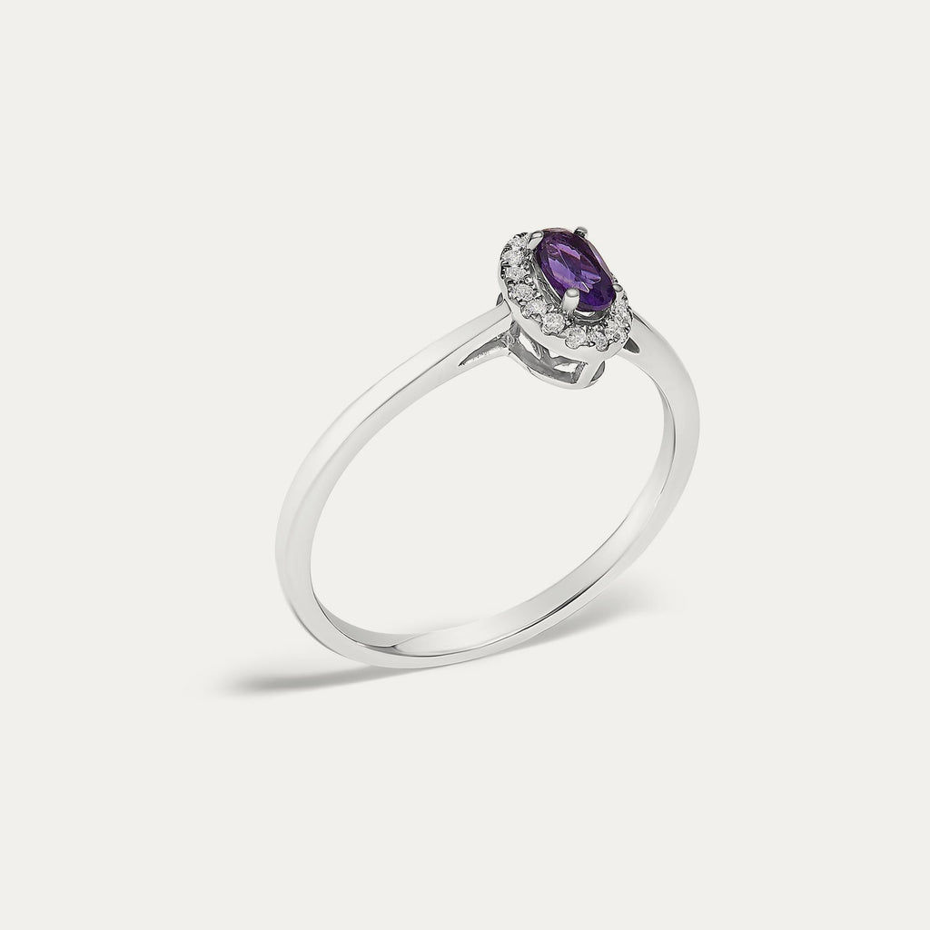 Angled view of the Origine birthstone halo ring in 10K white gold with an oval amethyst and its halo of natural diamonds