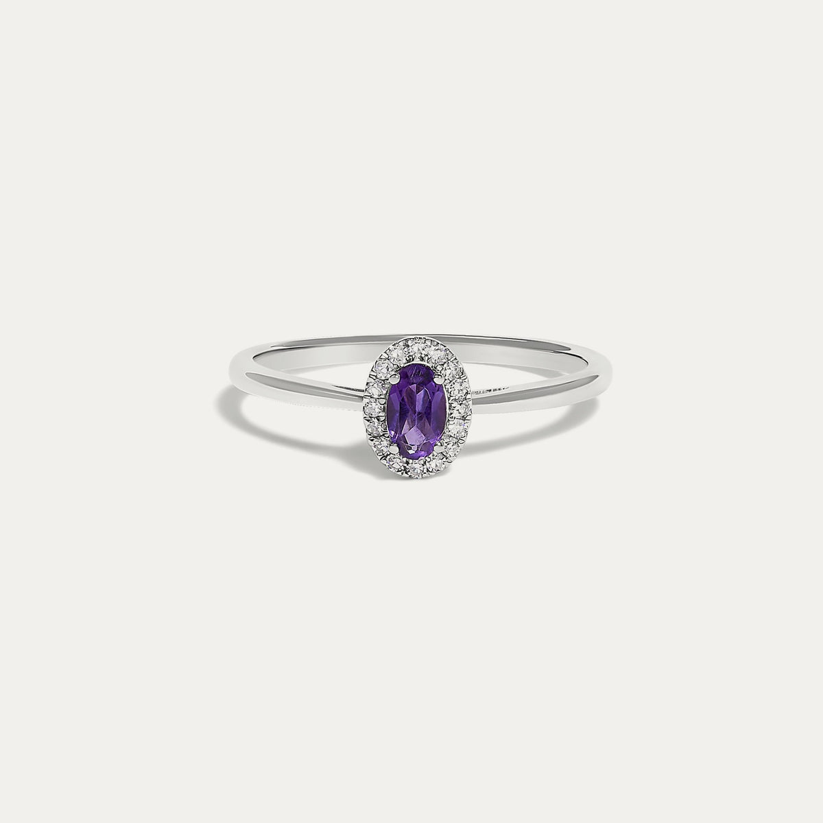 Front view of the Origine birthstone halo ring in 10K white gold with an oval amethyst crowned by a halo of natural diamonds