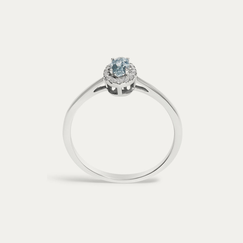Face view of the Origine birthstone halo ring in 10K white gold with an oval aquamarine crowned by a halo of natural diamonds