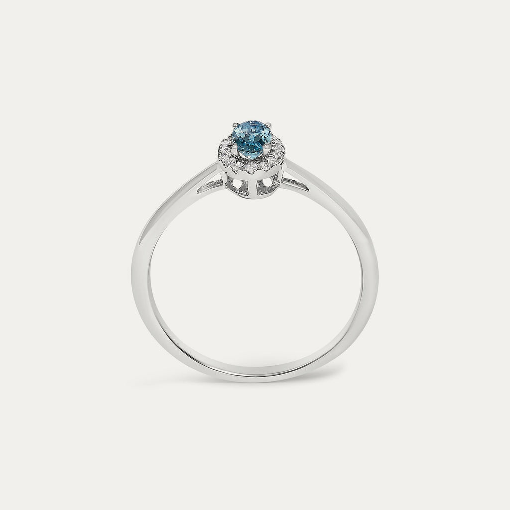 Face view of the Origine birthstone halo ring in 10K white gold with an oval blue topaz crowned by a halo of natural diamonds