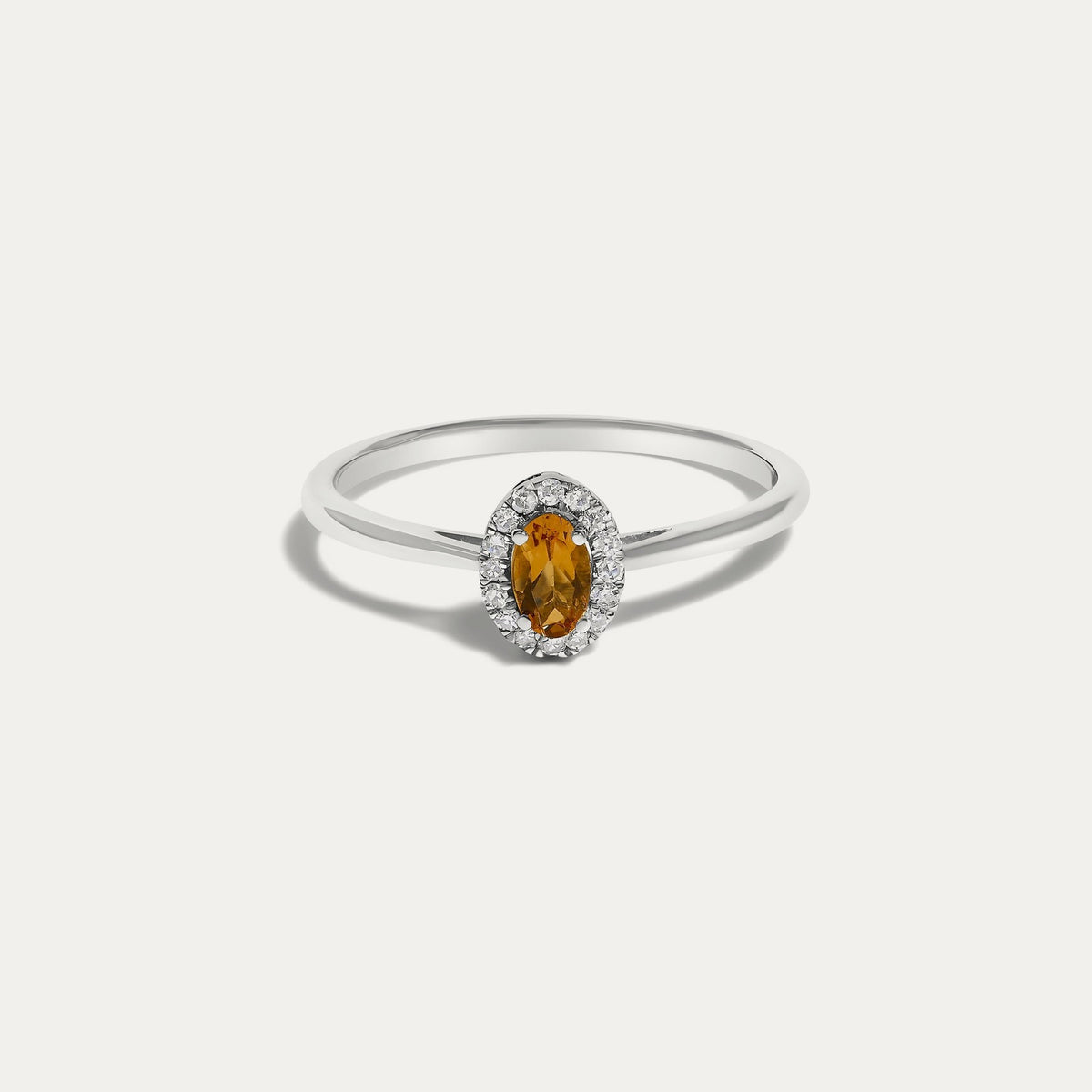 Front view of the Origine birthstone halo ring in 10K white gold with an oval citrine crowned by a halo of natural diamonds