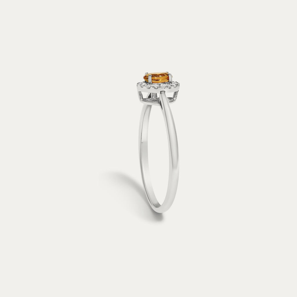 Profile view of the Origine birthstone halo ring in 10K white gold showing the raised halo setting with an oval citrine above the slim band