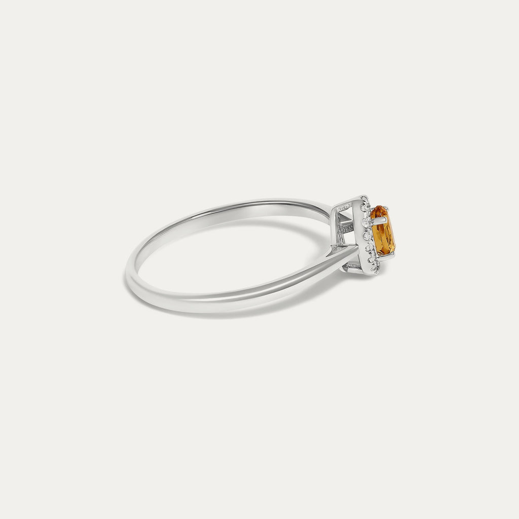 Side view of the Origine birthstone halo ring in 10K white gold with an oval citrine and a halo of natural diamonds above the slim band