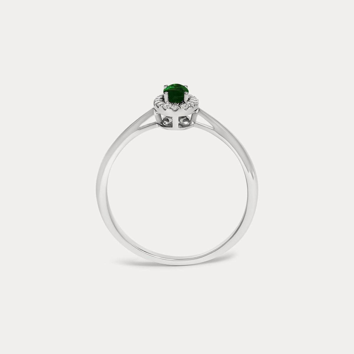Face view of the Origine birthstone halo ring in 10K white gold with an oval emerald crowned by a halo of natural diamonds