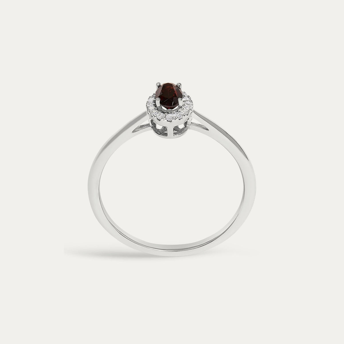 Face view of the Origine birthstone halo ring in 10K white gold with an oval garnet crowned by a halo of natural diamonds