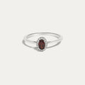 Front view of the Origine birthstone halo ring in 10K white gold with an oval garnet crowned by a halo of natural diamonds