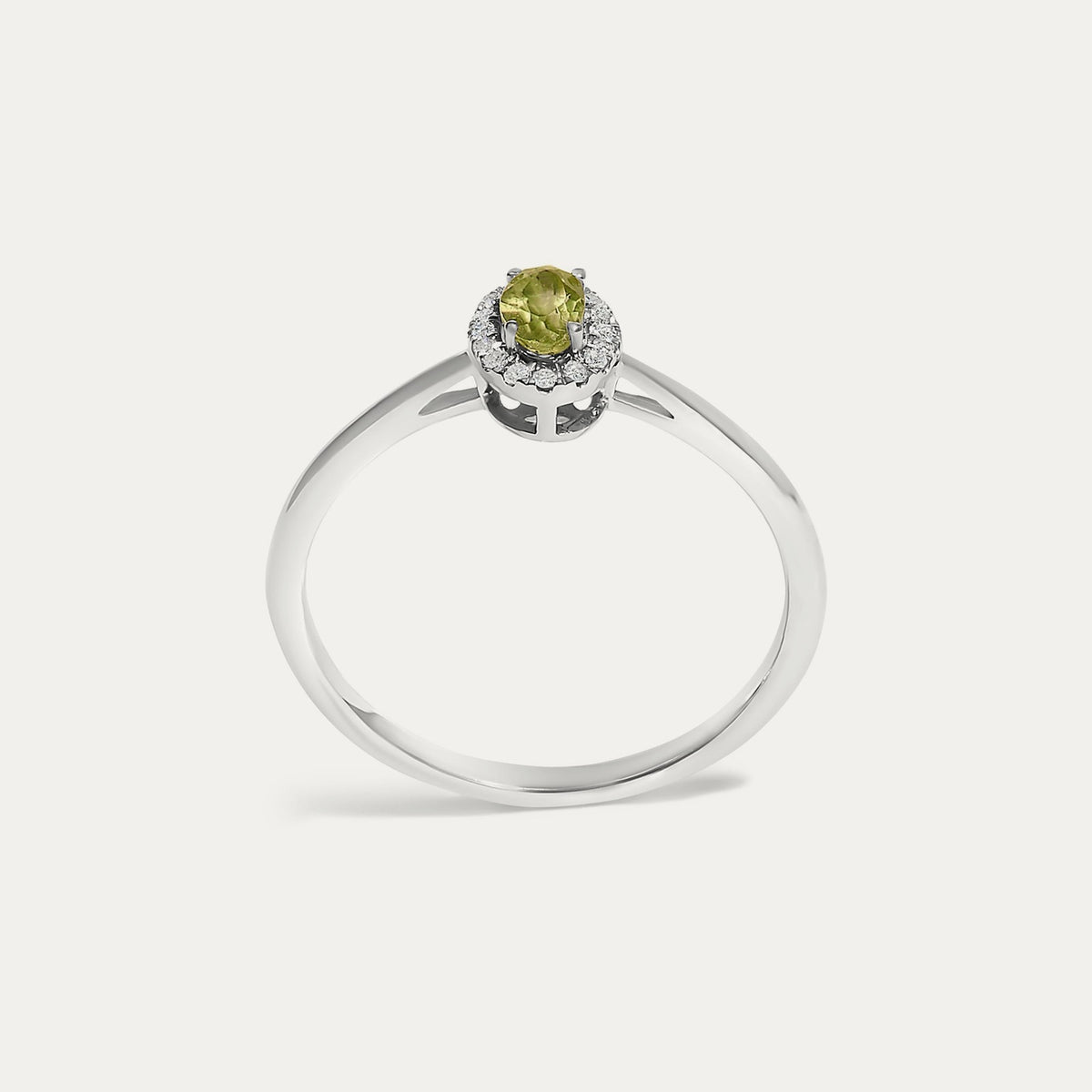 Face view of the Origine birthstone halo ring in 10K white gold with an oval peridot crowned by a halo of natural diamonds