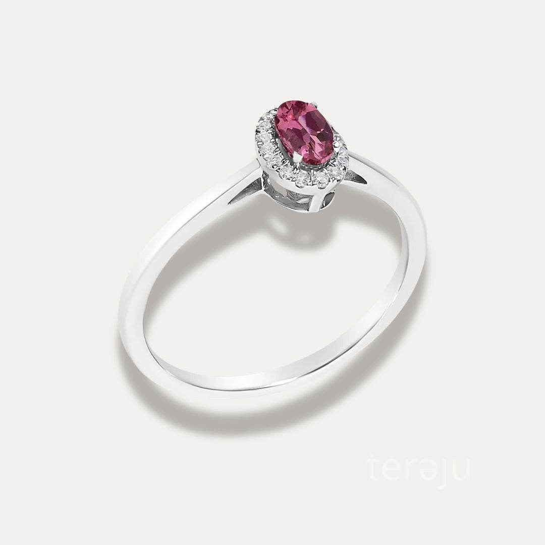 Angled view of the Origine birthstone halo ring in 10K white gold with the oval pink tourmaline and its halo of natural diamonds