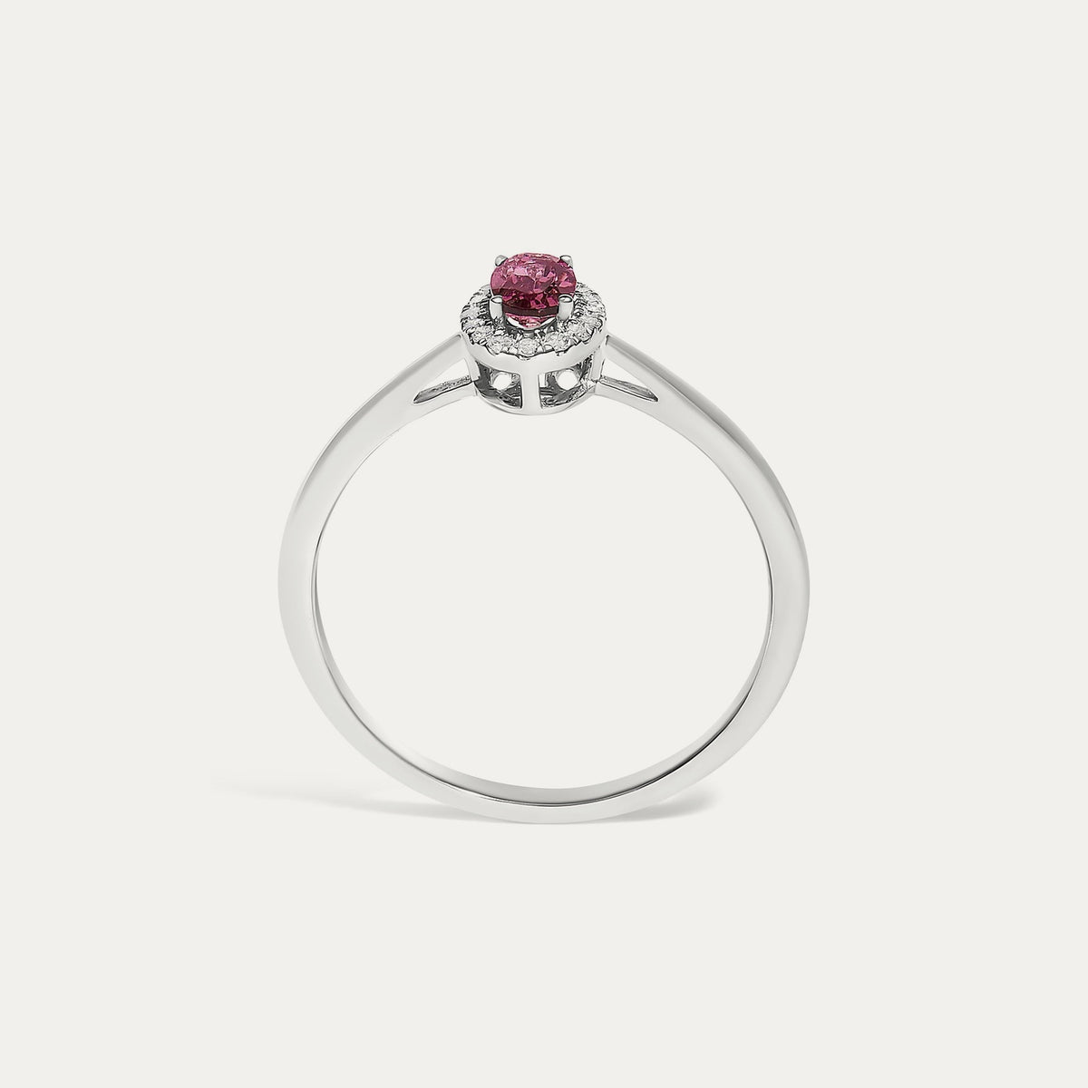 Face view of the Origine birthstone halo ring in 10K white gold with an oval pink tourmaline crowned by a halo of natural diamonds