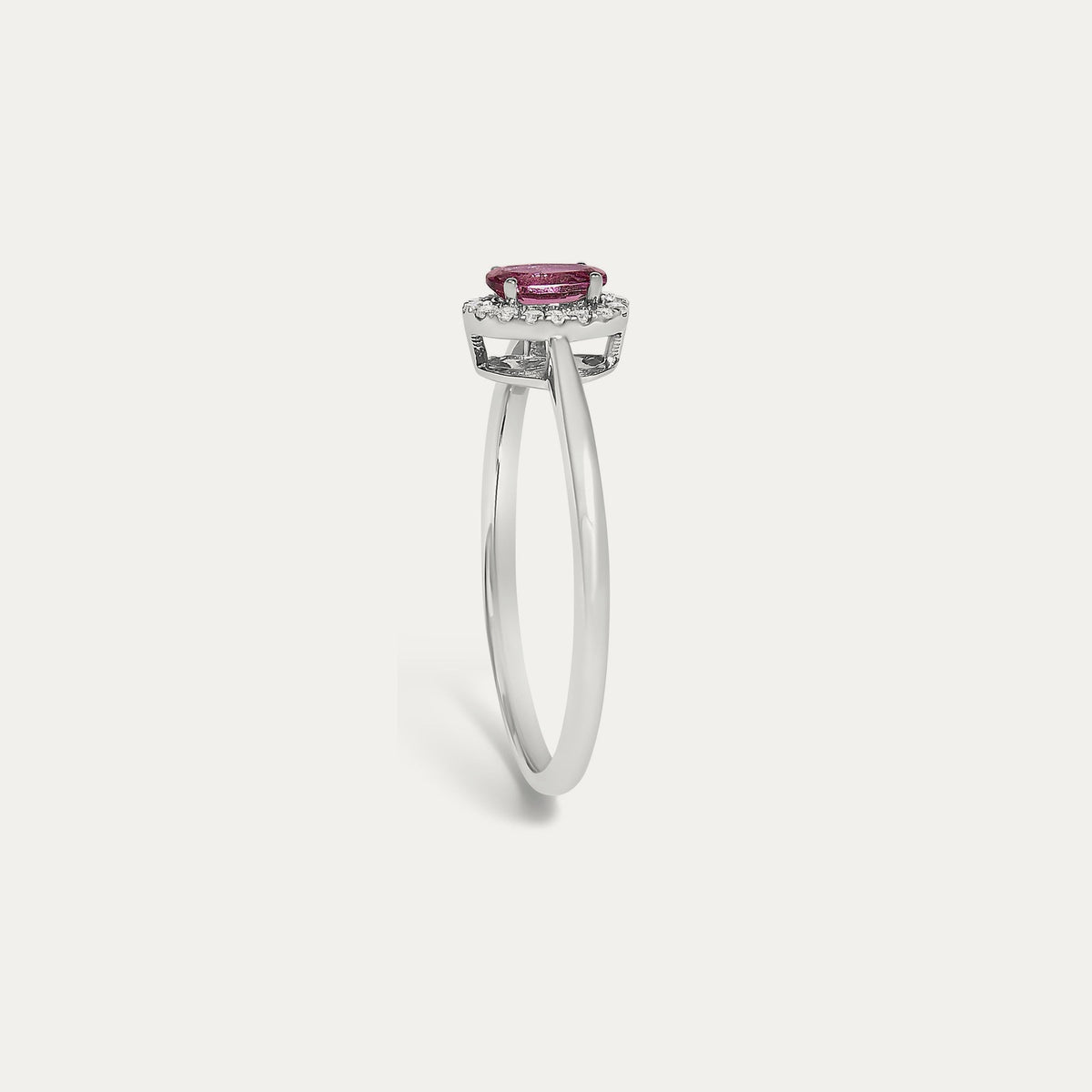 Profile view of the Origine birthstone halo ring in 10K white gold showing the raised halo setting with an oval pink tourmaline above the slim band