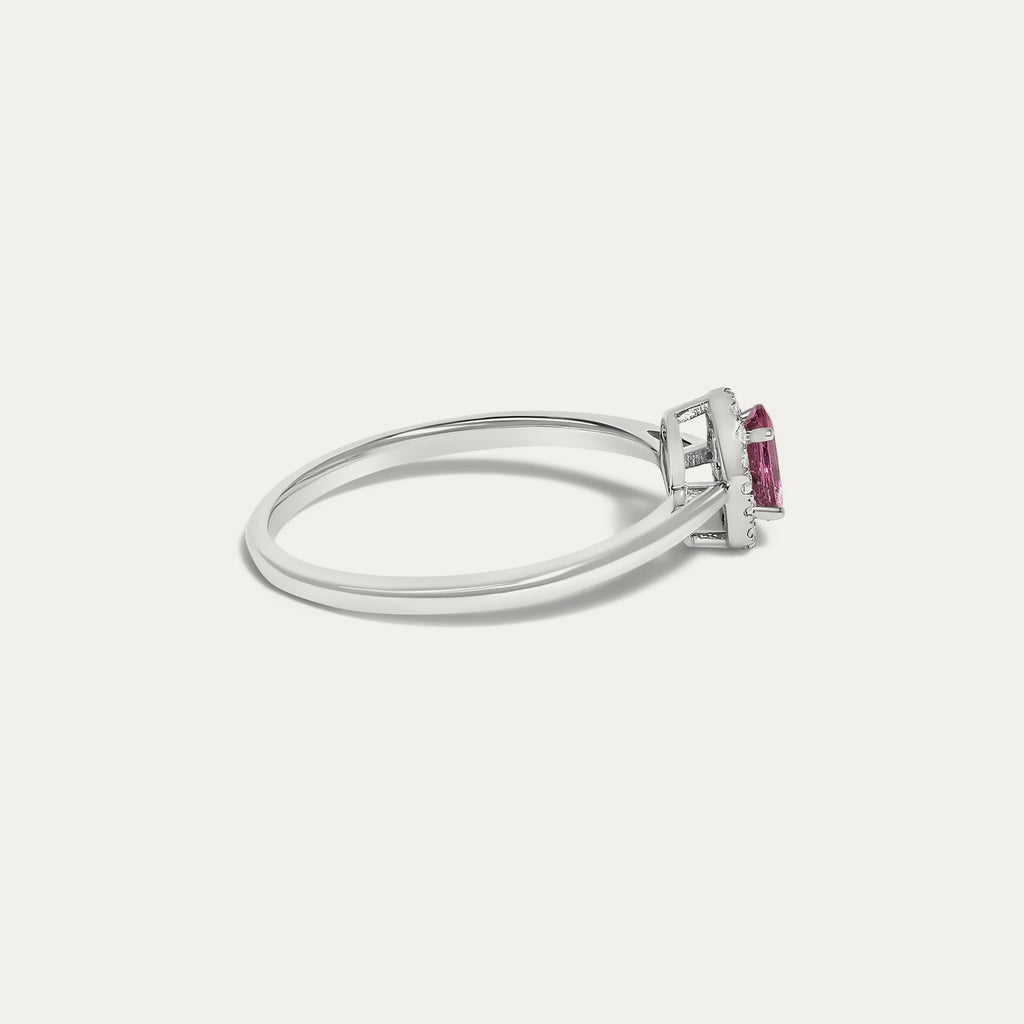 Side view of the Origine birthstone halo ring in 10K white gold with an oval pink tourmaline and a halo of natural diamonds above the slim band