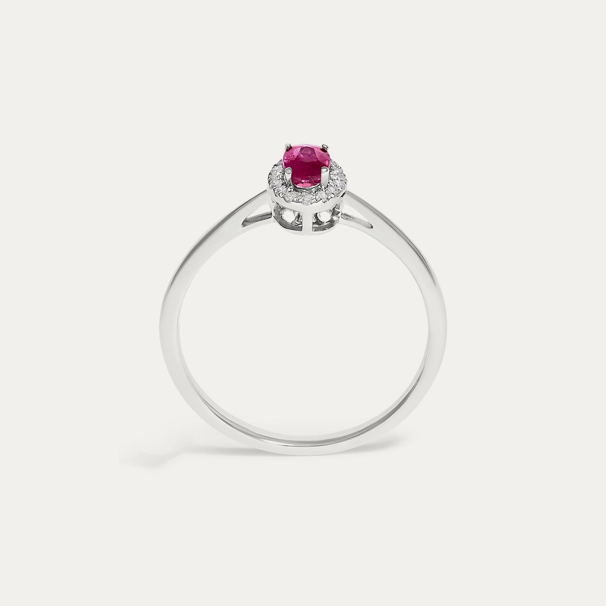 Face view of the Origine birthstone halo ring in 10K white gold with an oval ruby crowned by a halo of natural diamonds