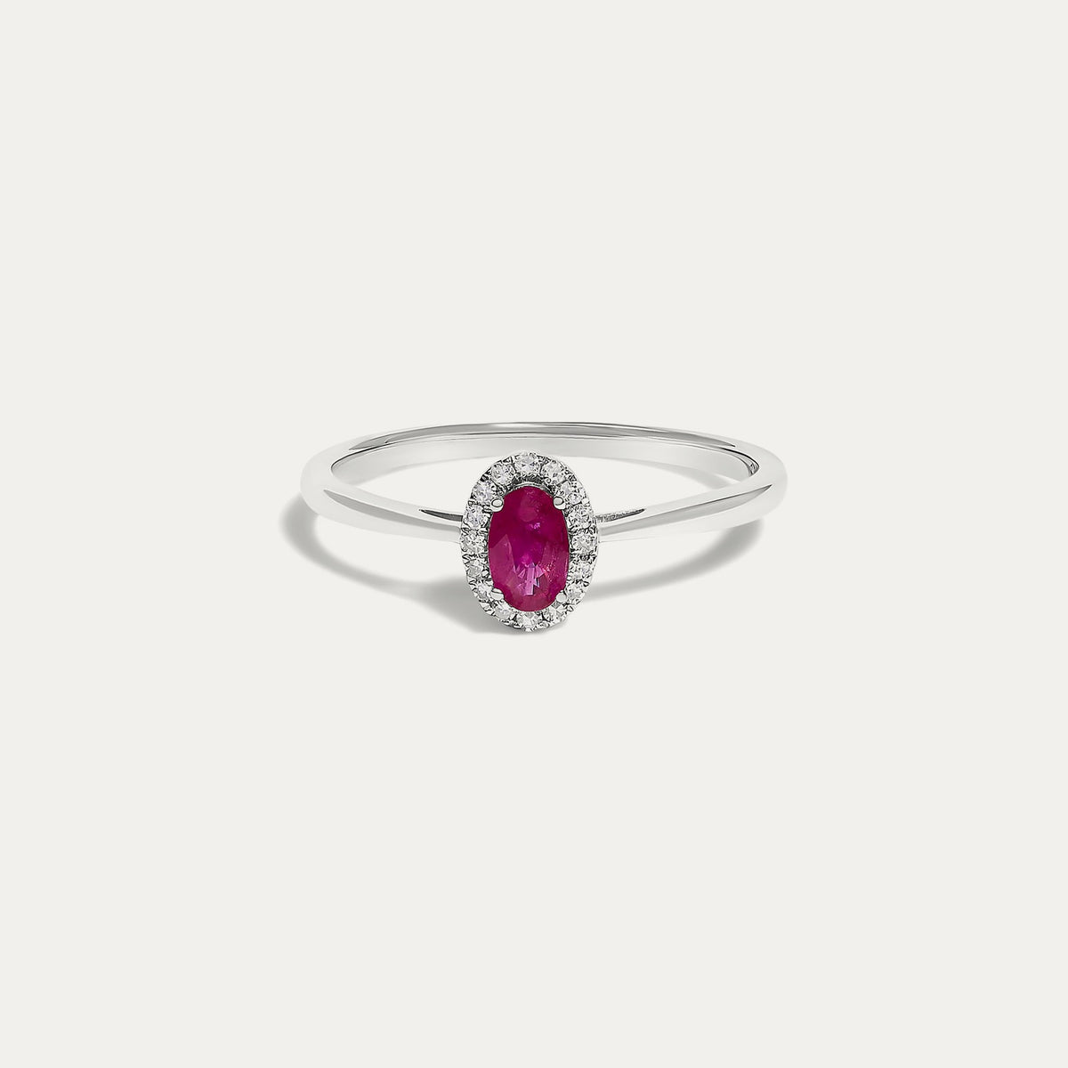 Front view of the Origine birthstone halo ring in 10K white gold with an oval ruby crowned by a halo of natural diamonds
