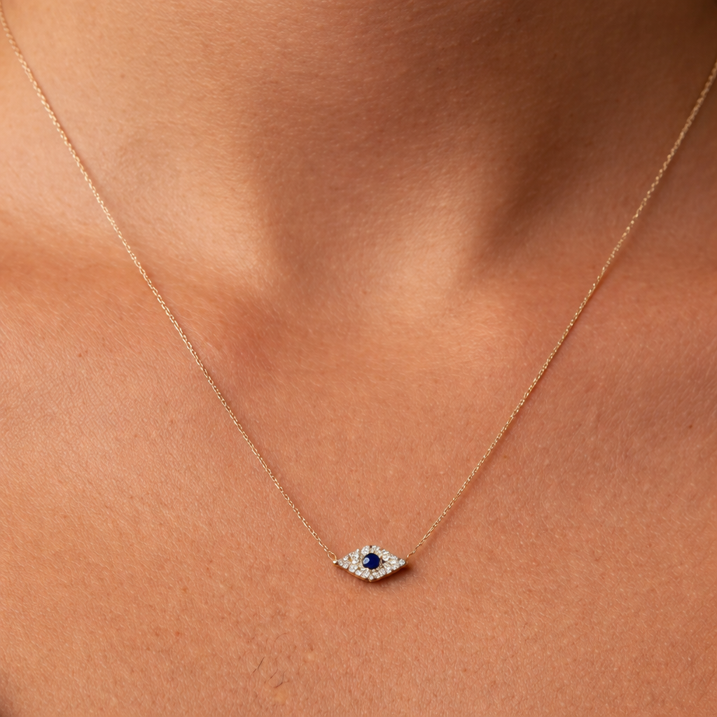 Gold necklace with a blue sapphire gemstone surrounded by diamonds pendant on a person's neck