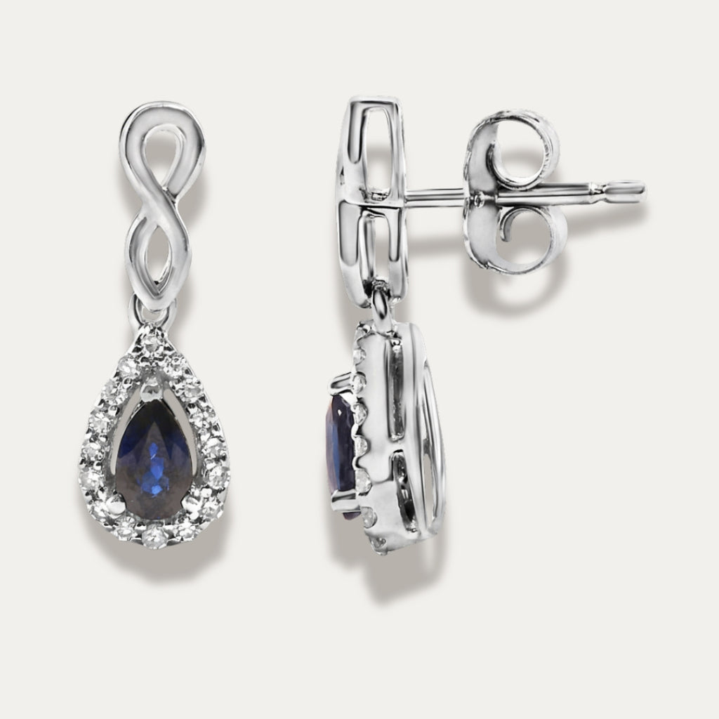 white gold earrings with sapphire gemstones on a grey background