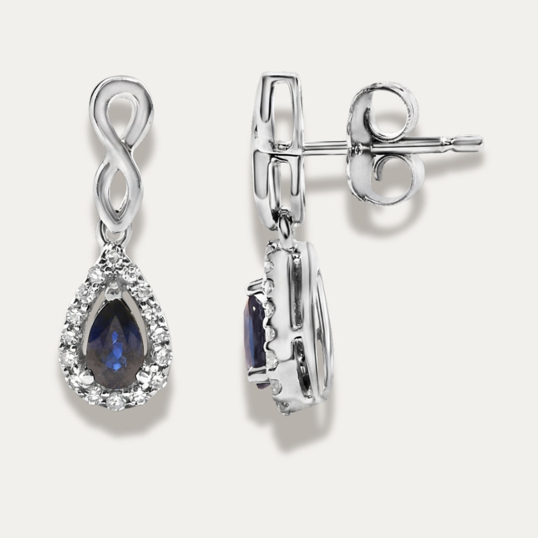 white gold earrings with sapphire gemstones on a grey background