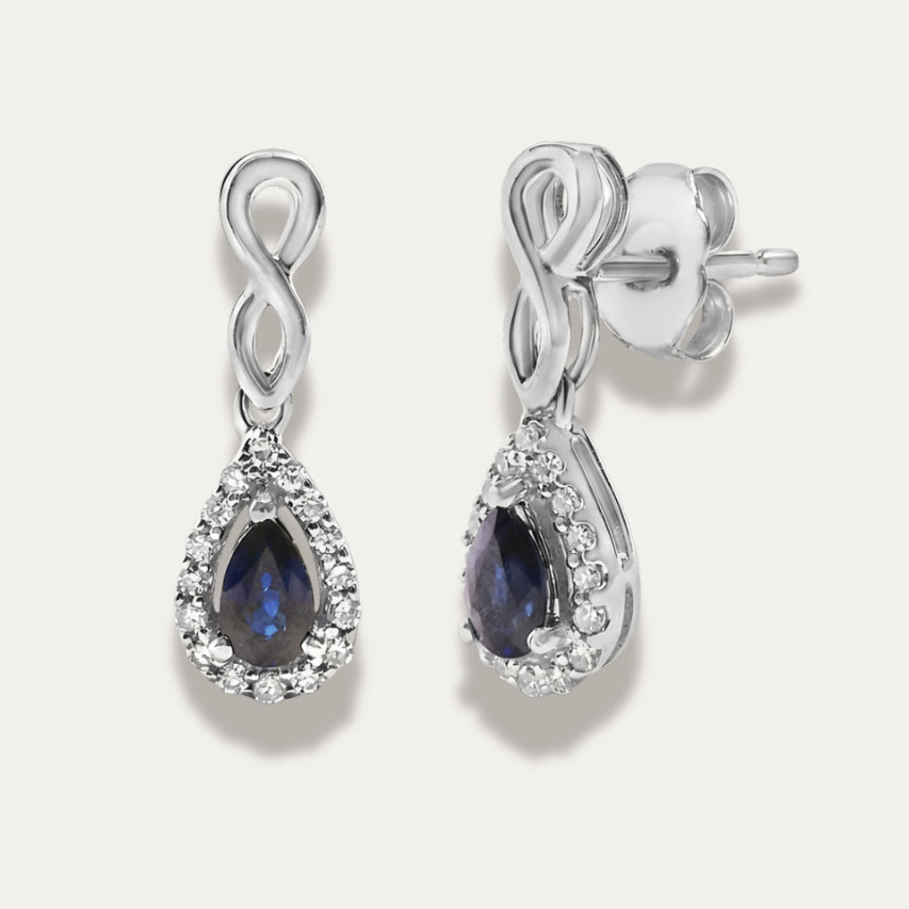 white gold earrings with sapphire gemstones on a grey background