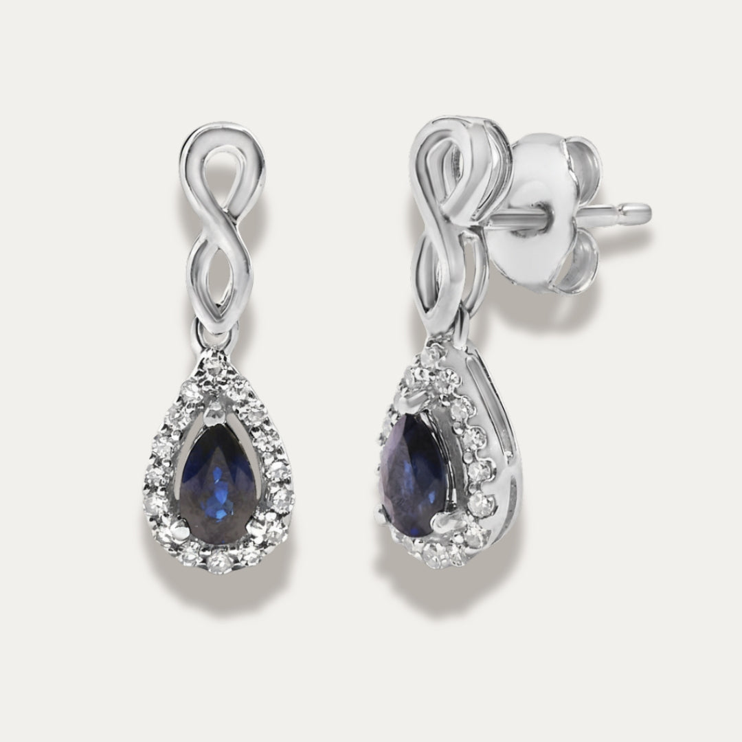 white gold earrings with sapphire gemstones on a grey background