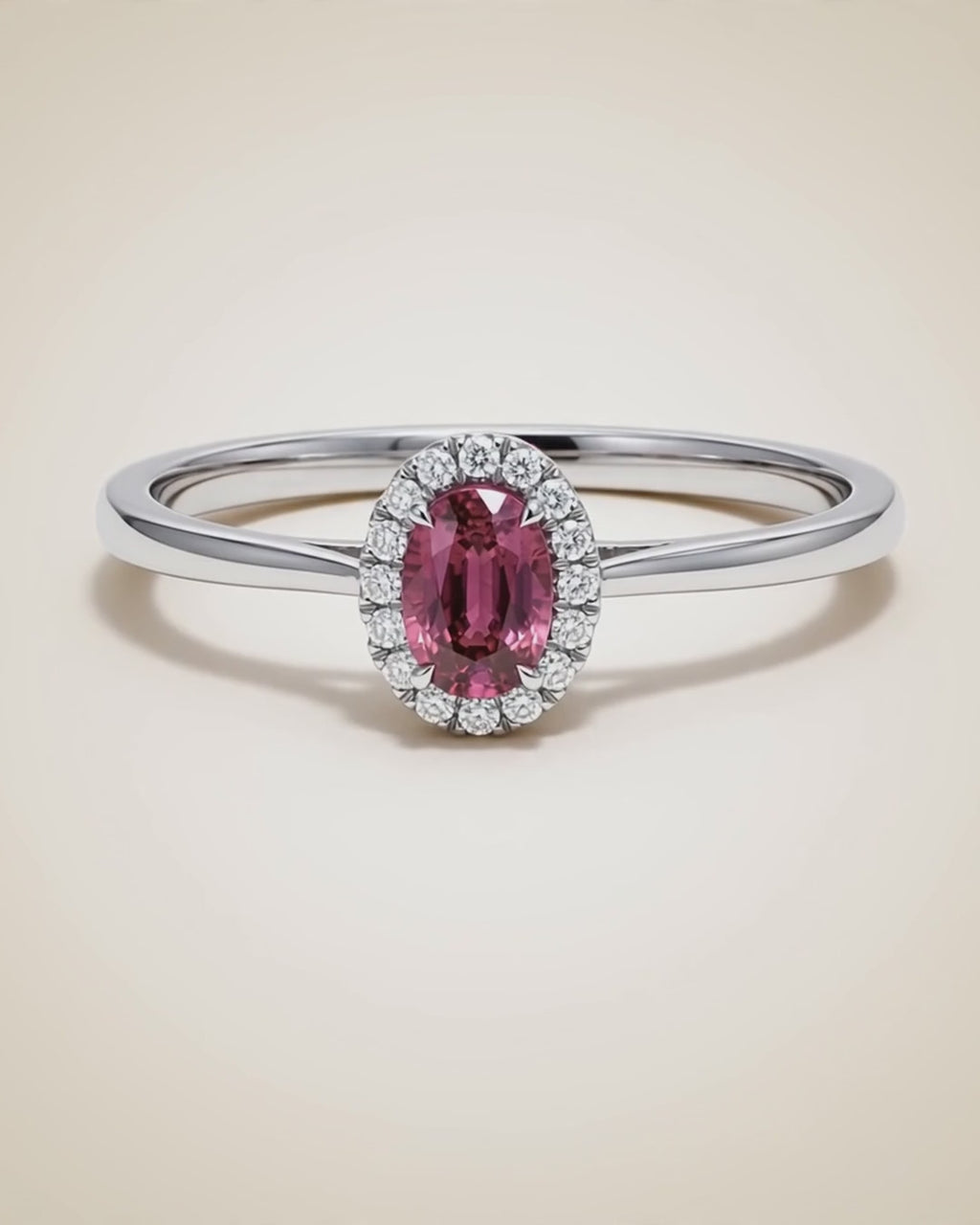 Video of the Origine birthstone halo ring in pink tourmaline rotating on a cream background
