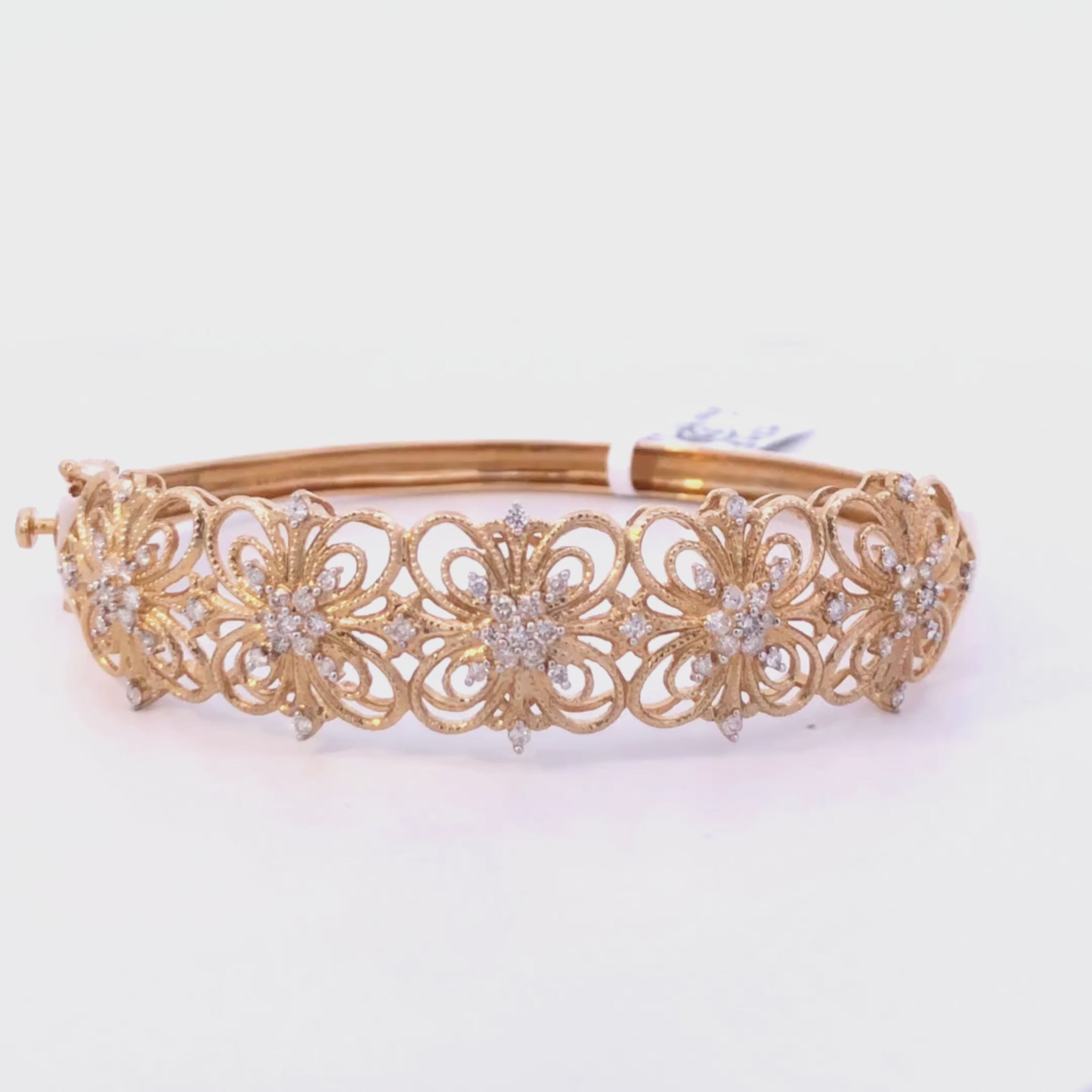 Gold diamond floral bangle bracelet on a light gray background