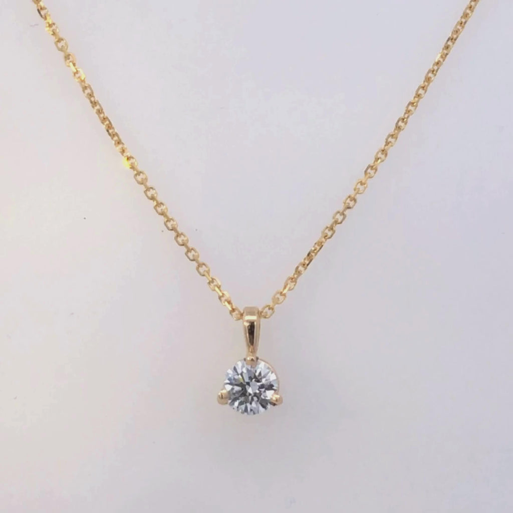 Gold pendant with a clear gemstone on a white background