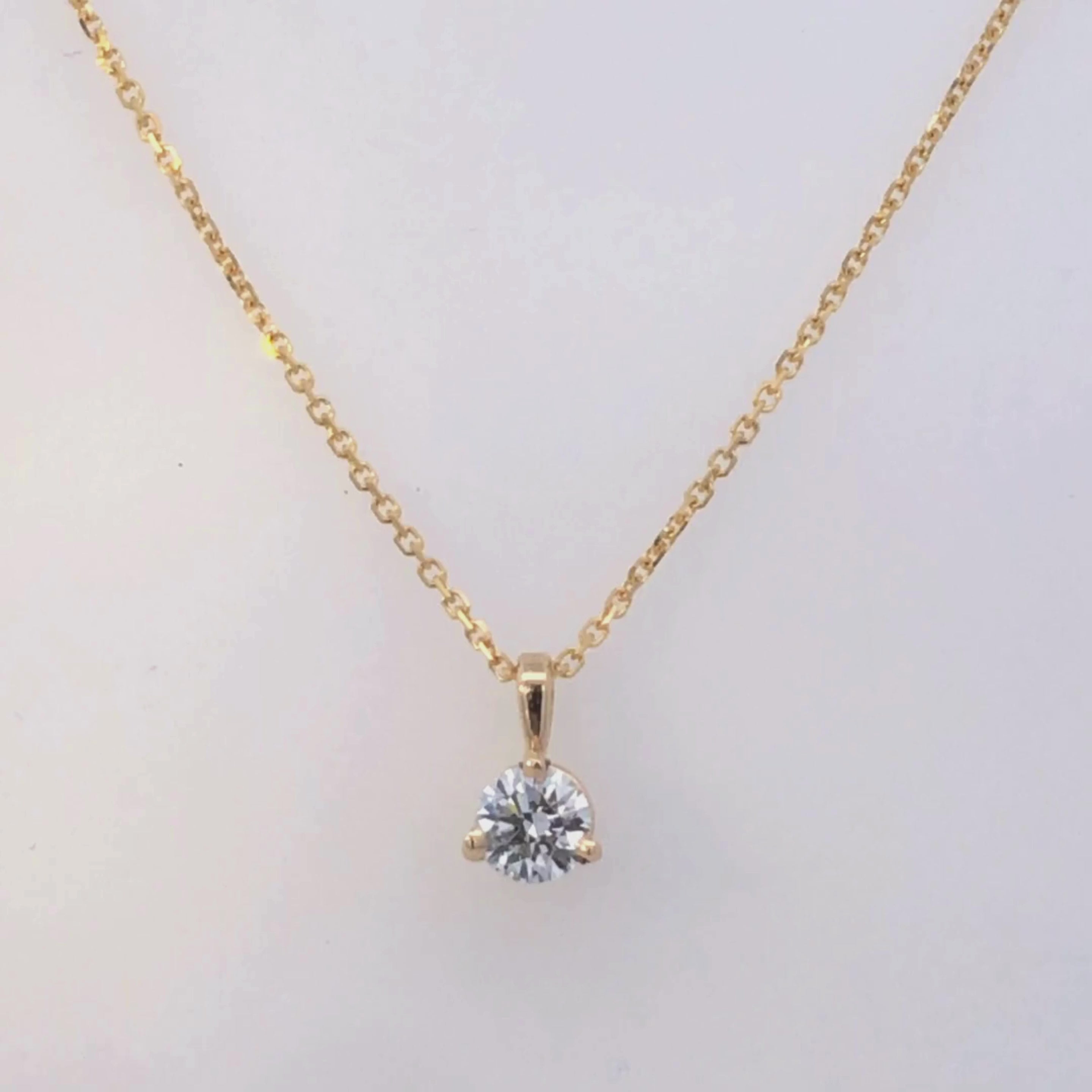 Gold pendant with a clear gemstone on a white background