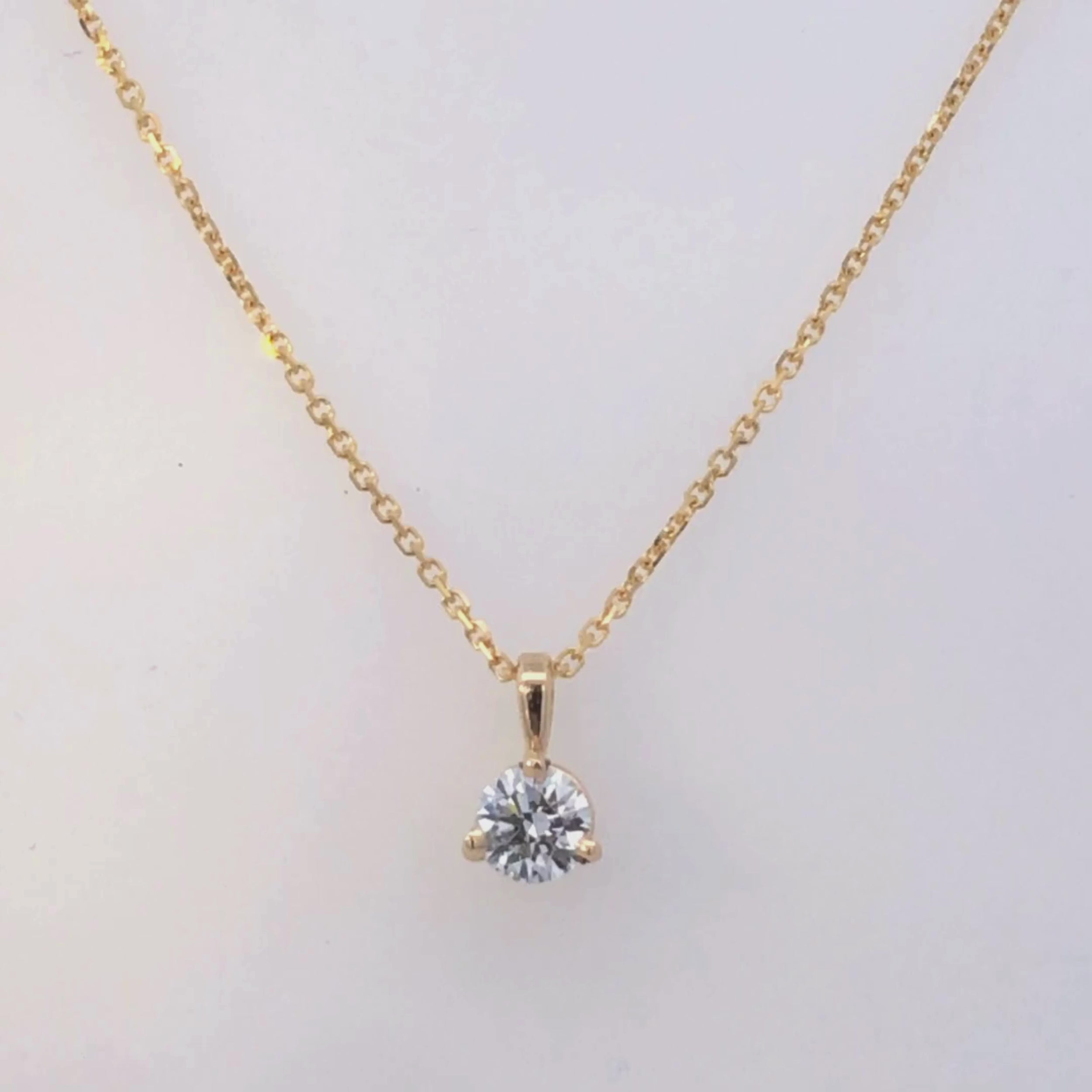 Gold pendant with a clear gemstone on a white background