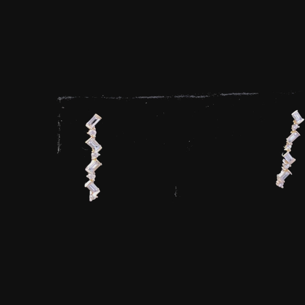 Video of gold zigzag earrings with diamonds on a black background